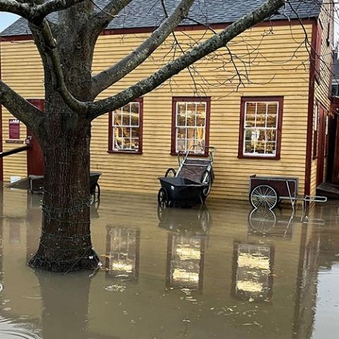 Yellow historic home surrounded by flood waters